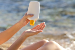 woman-putting-sunscreen-in-hand