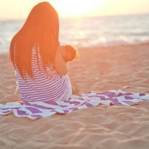 woman-on-beach-breasfeeding