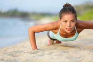 girl-doing-pushups-on-beach