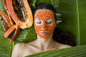 Woman with natural papaya skin care facial mask