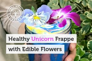  A glass cup of healthy unicorn frappe with edible flowers