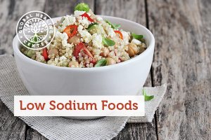A bowl of low sodium foods including quinoa, tomatoes, and spinach.