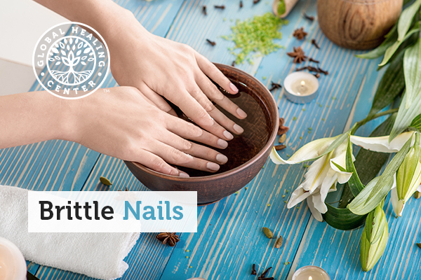 A woman soaking her nails in a homemade cuticle oil to strengthen nails. This is a natural remedy for brittle nails.