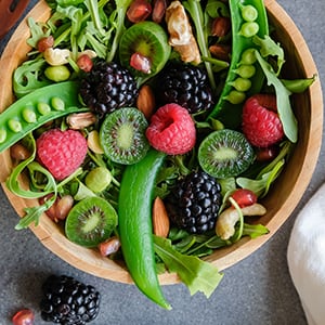 A salad of fresh fruit and vegetables in a bowl. Fruits and vegetables are a staple to the DASH diet.