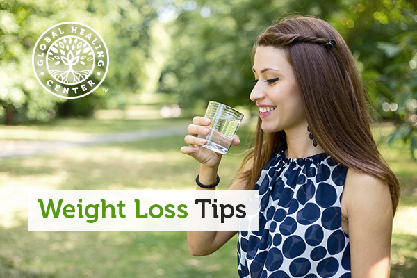A woman drinking a glass of water. A effective weight loss tip is to drink 6-8 glasses of water daily.