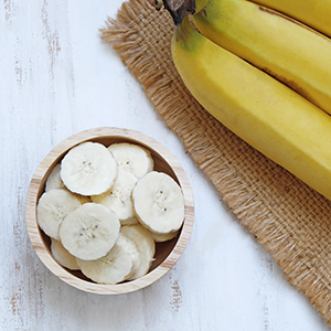 A couple of sliced and whole bananas. Bananas are an easy to digest food.