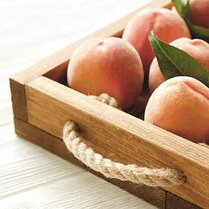 A basket of peaches. Peaches are a staple to a low-oxalate diet.