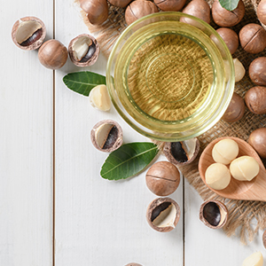A bowl of macadamia oil and macadamia nuts. Macadamia nuts are one of the best sources of omega-7.